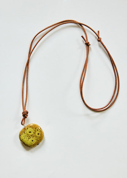 Chartreuse speckled ceramic pendant on adjustable brown leather cord necklace