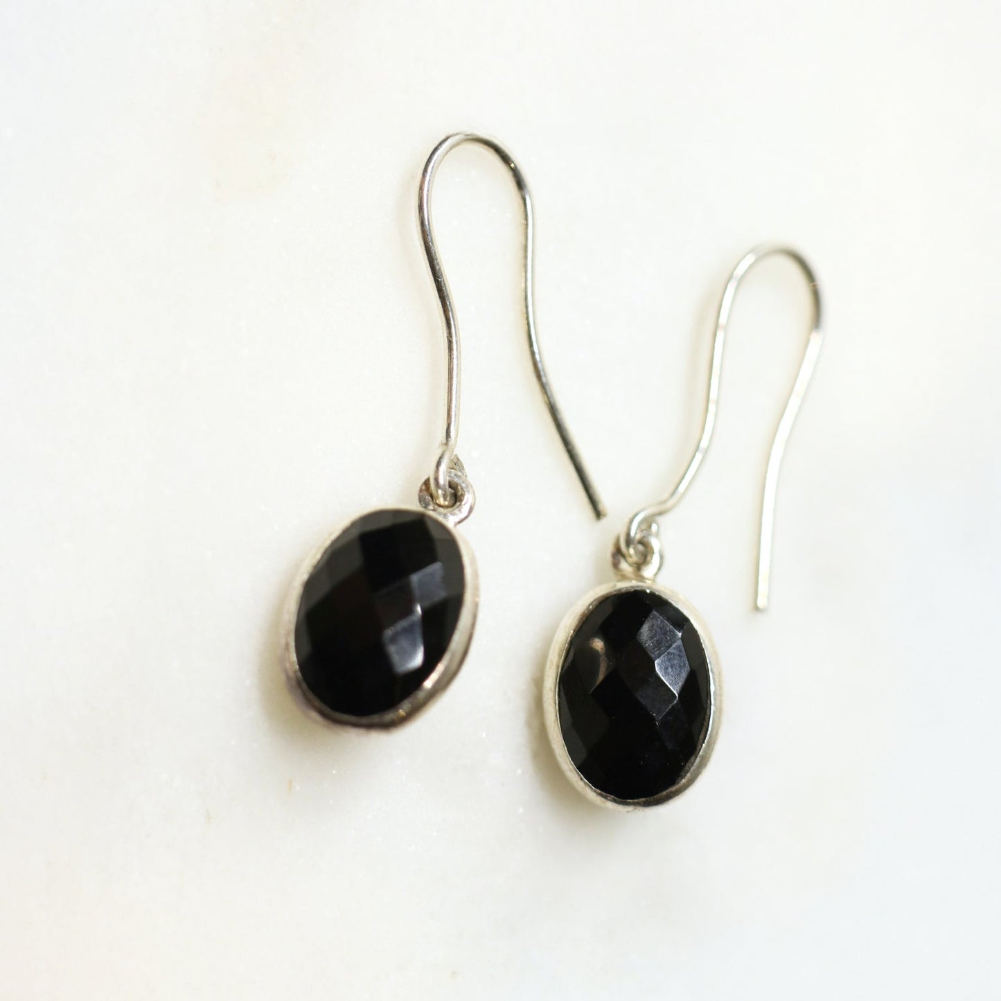 Pair of black stone earrings on a white background