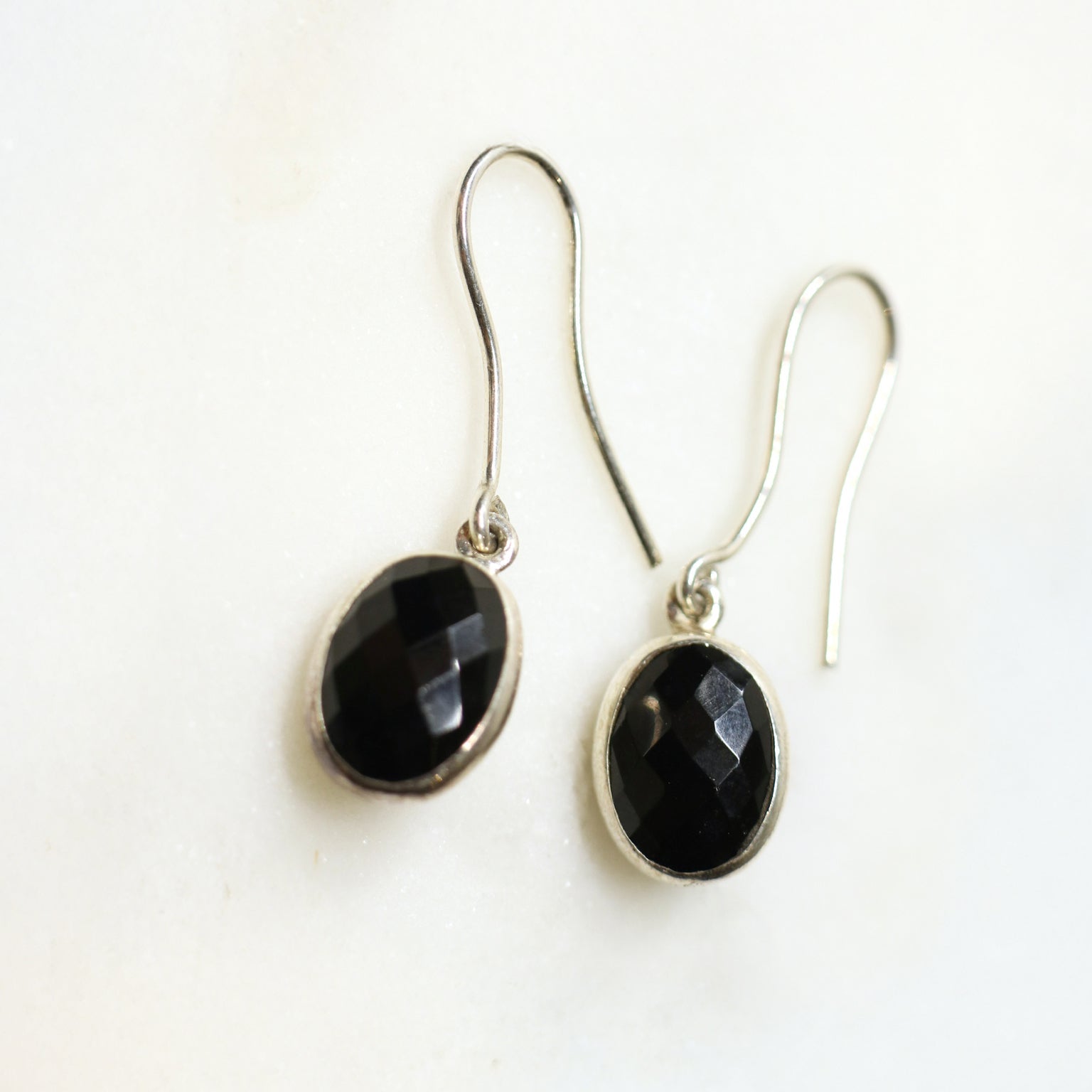 Pair of black stone earrings on a white background