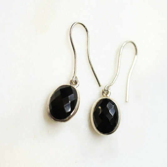 Pair of black stone earrings on a white background